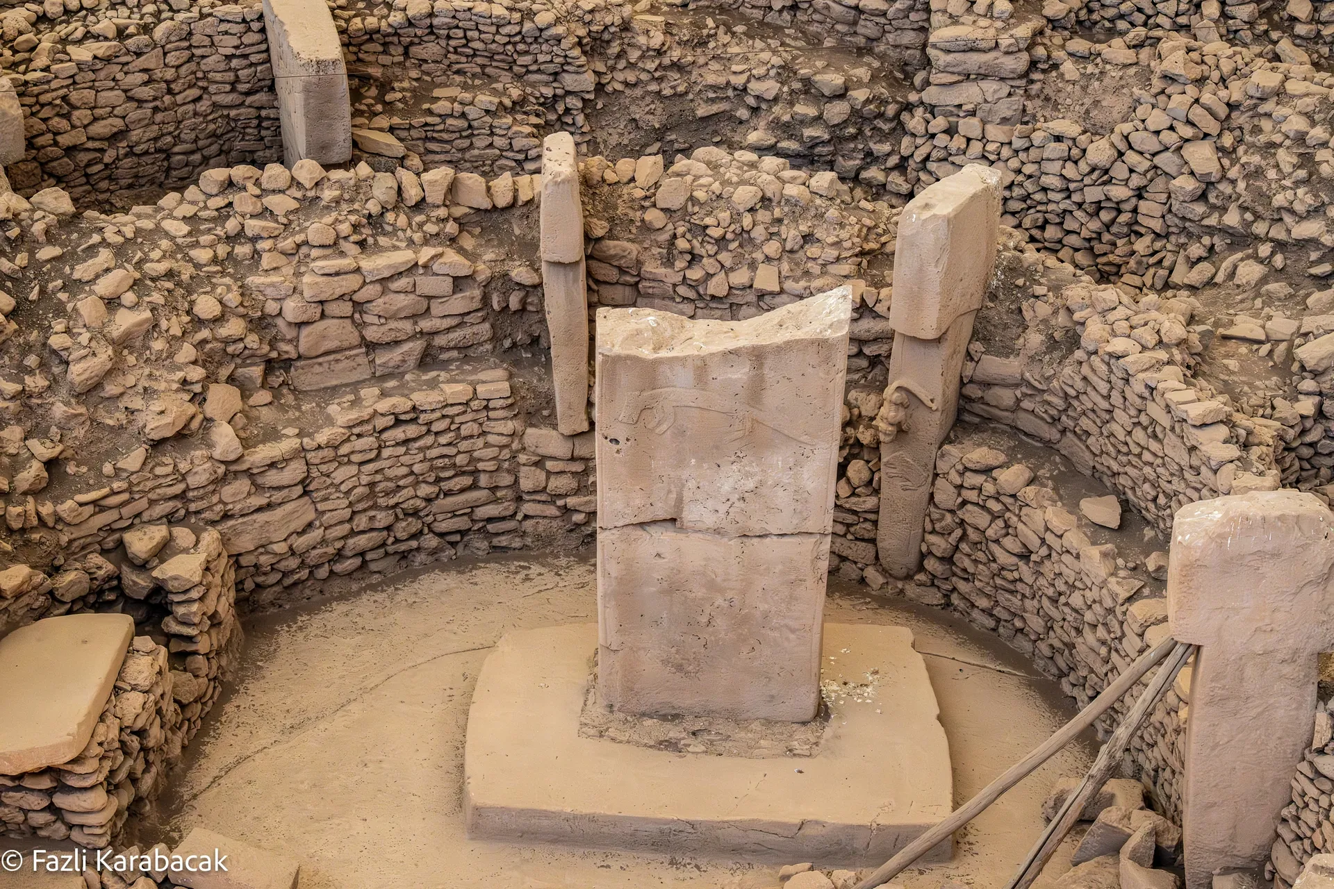 Dramatic excavation view of Göbekli Tepe with ancient pillars emerging from earth